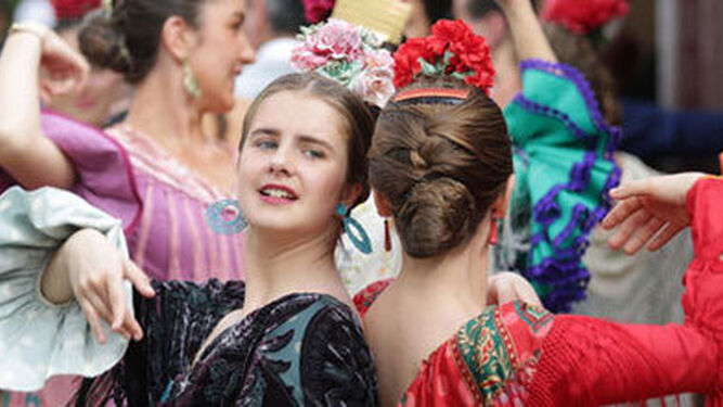 Dos chicas vestidas de gitana bailan a la puerta de una caseta/Diario de Sevilla